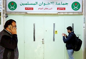 Një burrë fotografon hyrjen kryesore të zyrës së selisë të ‘ Vëllazërisë Myslimane’ , vulosjen me dyll të zyrës, pasi ishte bastisur dhe mbyllur nga policia, në Aman, Jordan, të mërkurën.