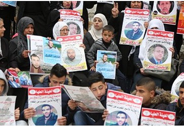 Protestuesit mbajnë postera gjatë një demonstrate, kërkojnë lirimin e palestinezëve të cilët organizojnë një grevë urie në burgjet izraelite, përballë ndërtesës së Kryqit të Kuq Ndërkombëtar në Ramallah, në Bregun Perëndimor, më 28 shkurt, 2017.